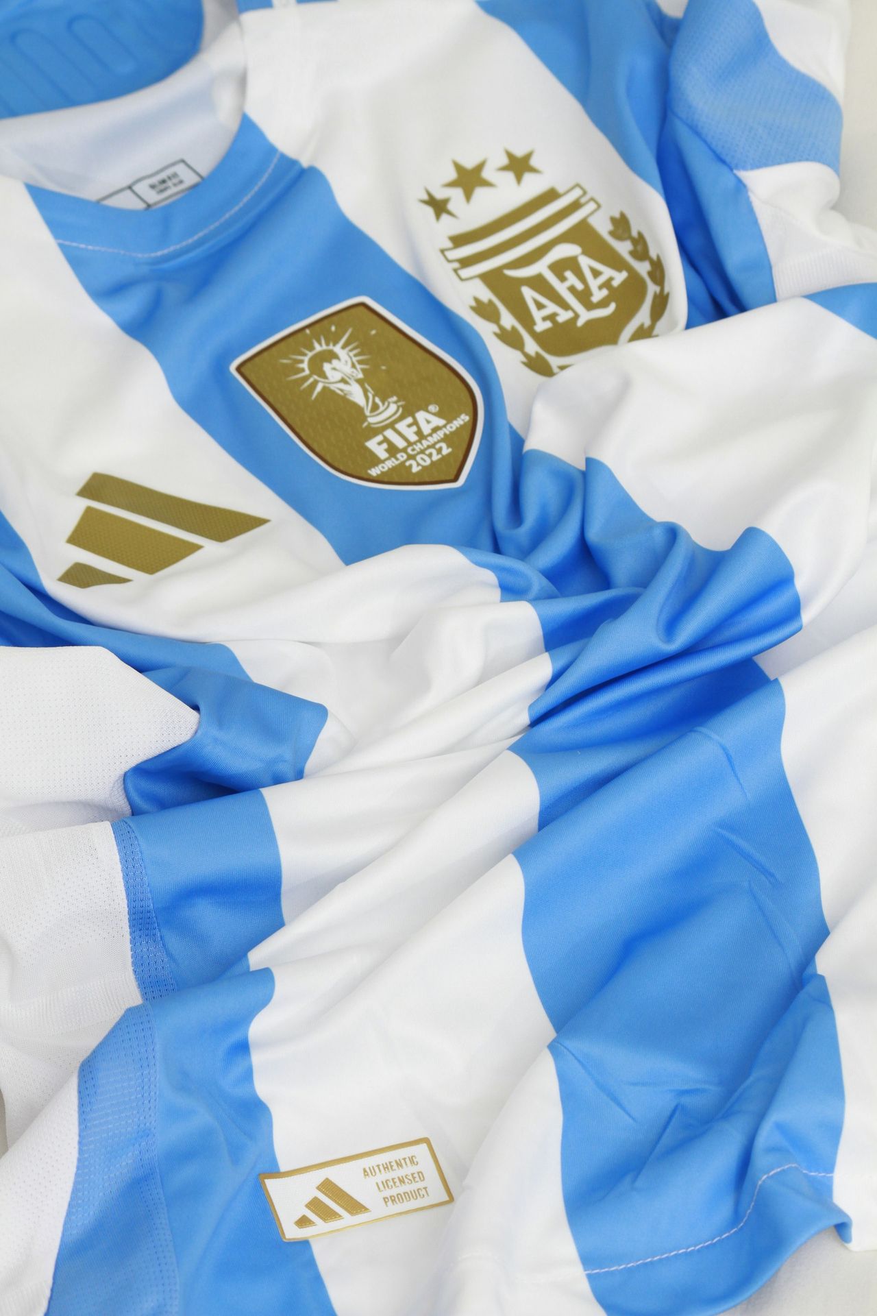 a blue and white soccer jersey laying on top of a bed